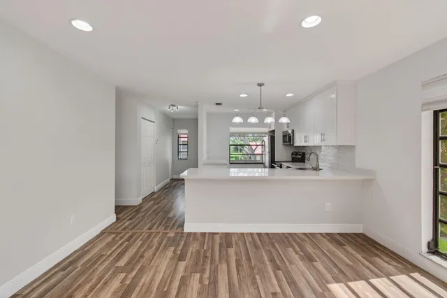 a view of a room with wooden floor a ceiling fan