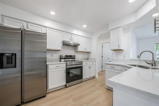 a kitchen with cabinets stainless steel appliances and sink