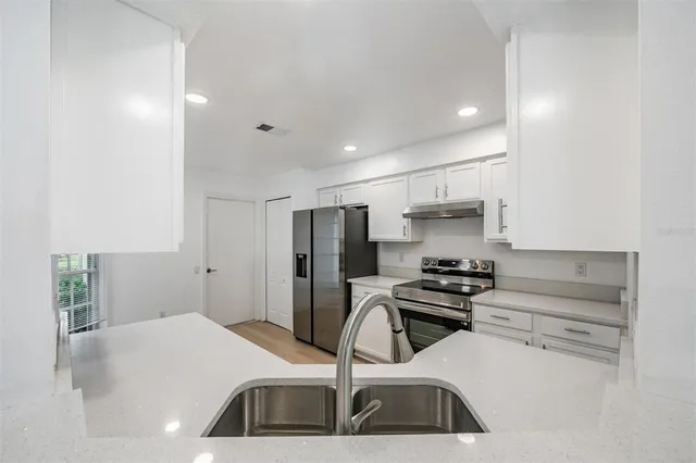 a kitchen with kitchen island a sink appliances and cabinets