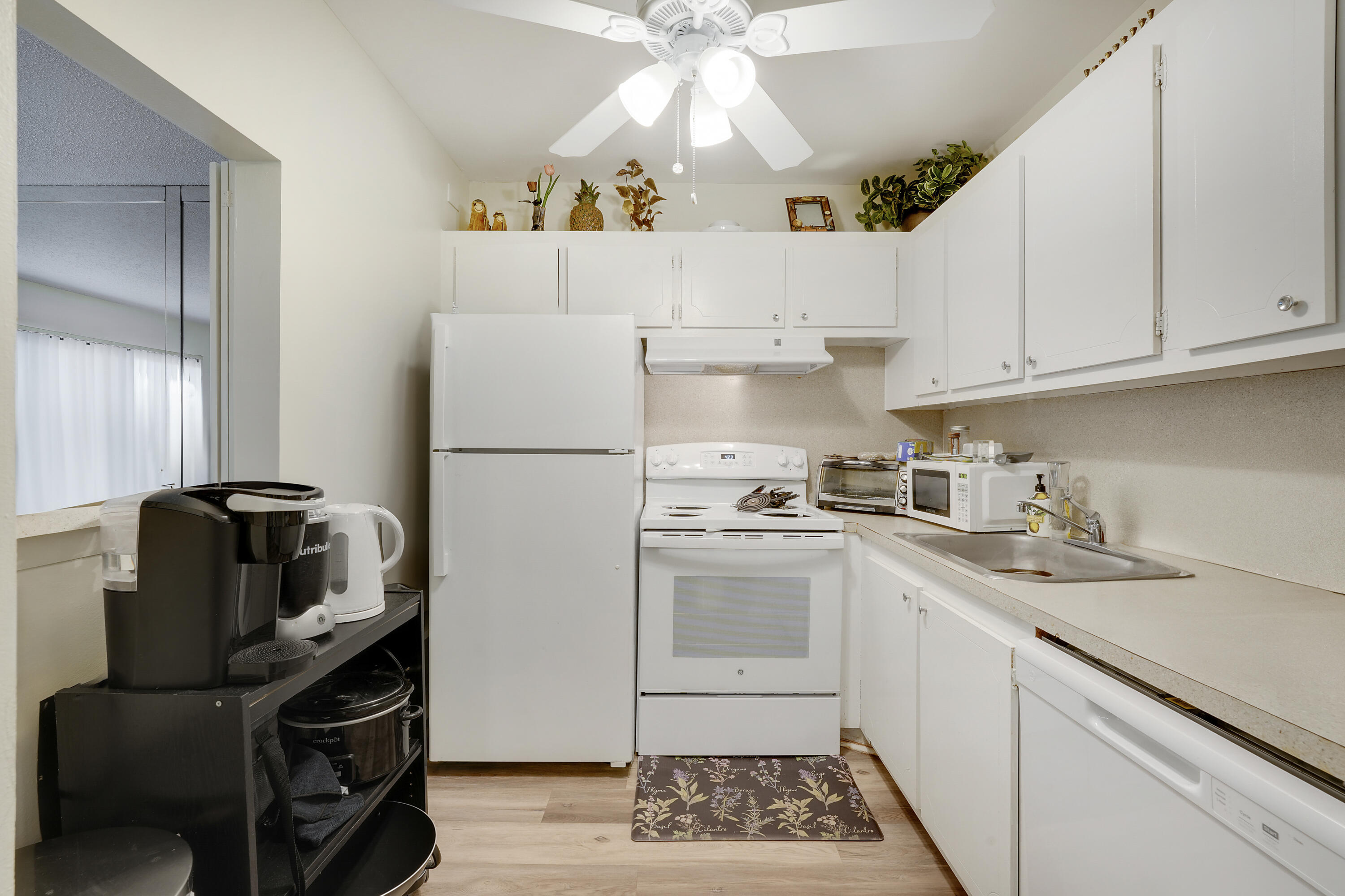 146 Mansfield D Boca Raton, FL 33434 - Photo 6 of 12 a kitchen with a sink appliances and cabinets