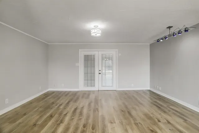 a view of an empty room with wooden floor
