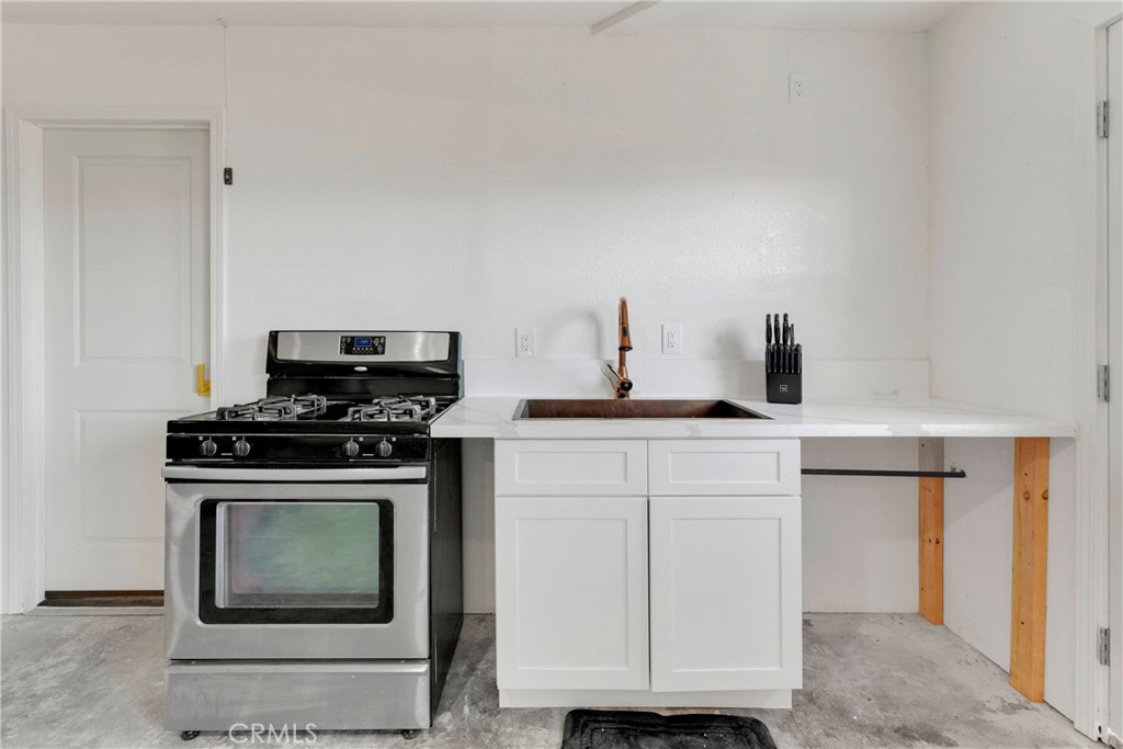 8263 3rd Avenue Hesperia, CA 92345 - Photo 31 of 56 a kitchen with white cabinets and appliances