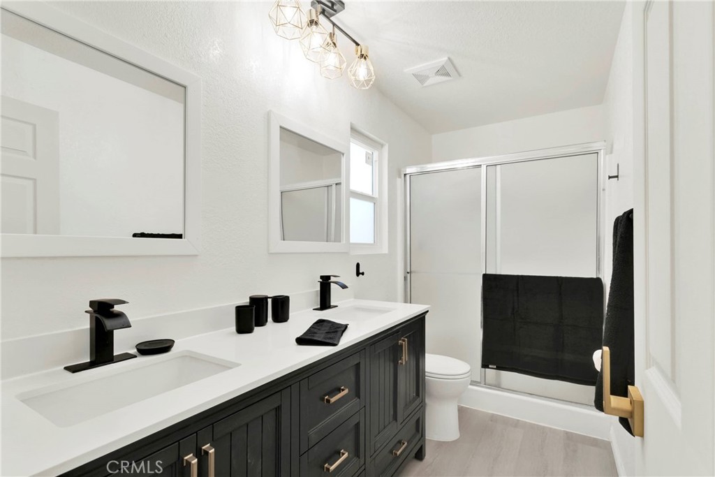 8263 3rd Avenue Hesperia, CA 92345 - Photo 32 of 56 a bathroom with double vanity and a mirror