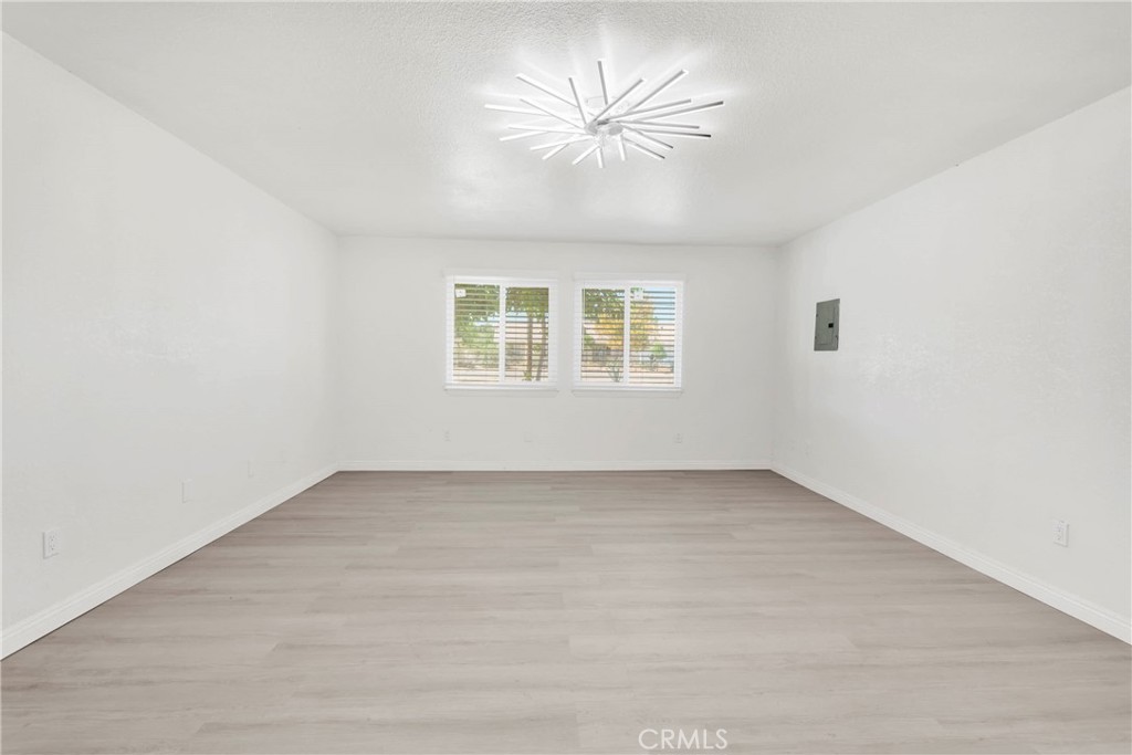 8263 3rd Avenue Hesperia, CA 92345 - Photo 34 of 56 an empty room with a chandelier fan and windows