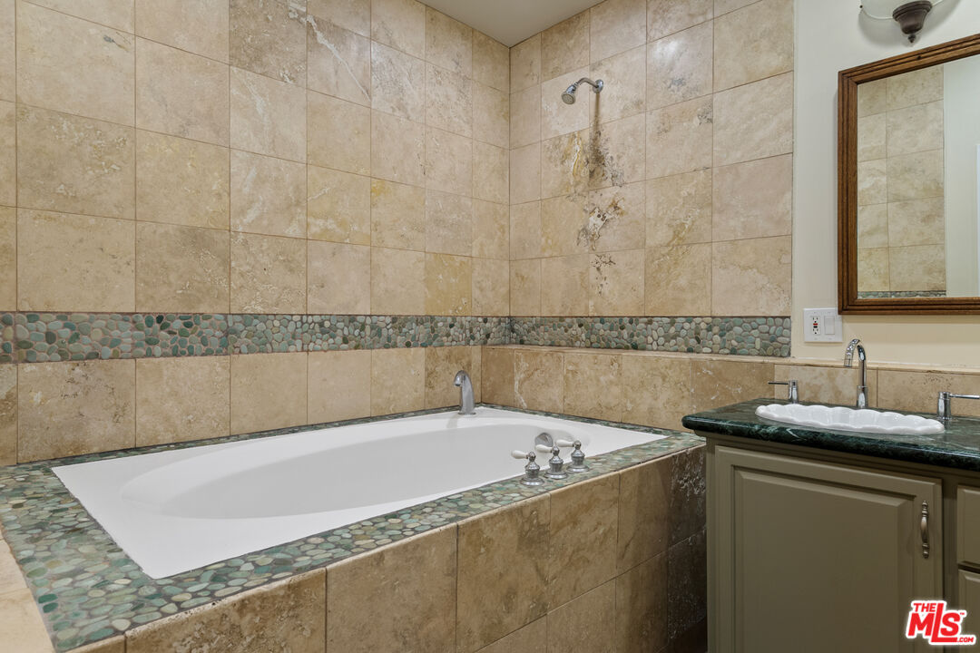 20912 Fontaine Road Topanga, CA 90290 - Photo 36 of 52 a bathroom with a granite countertop bathtub and a sink