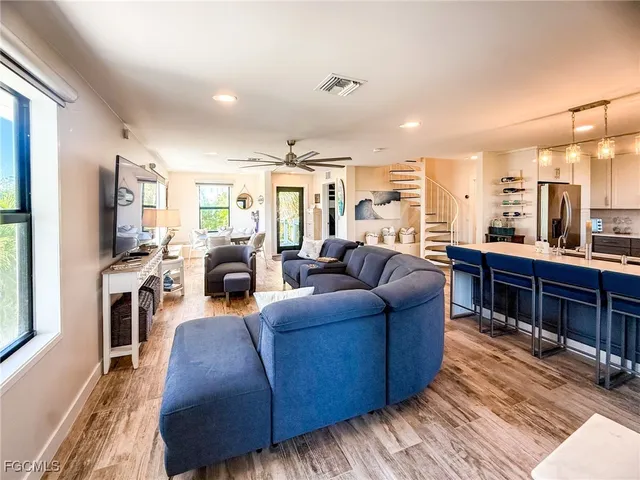 a kitchen with stainless steel appliances kitchen island granite countertop a table chairs and a refrigerator