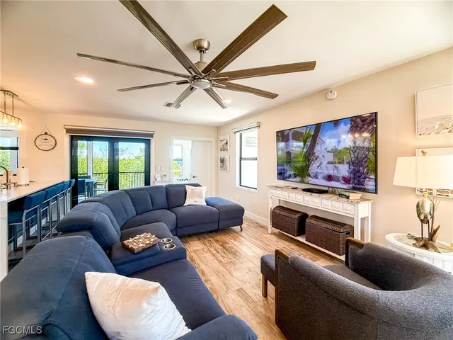 a living room with furniture ceiling fan and a wooden floor