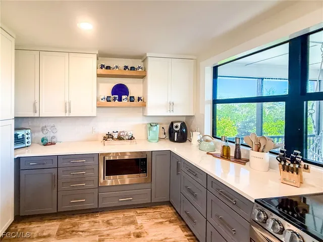 a kitchen with stainless steel appliances granite countertop a stove and a large window