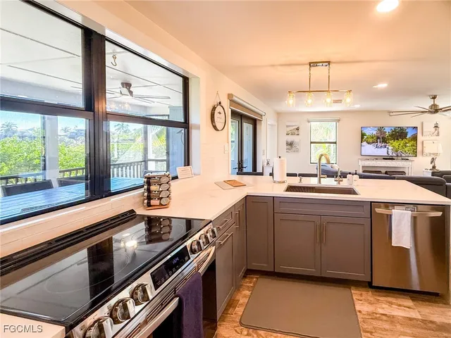 a living room with furniture a large window and a wooden floor
