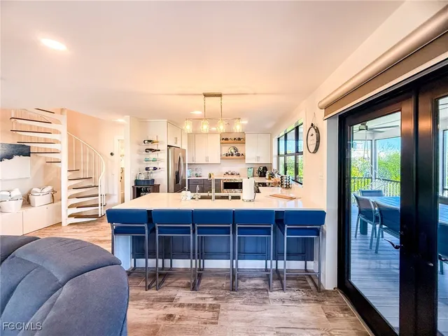 a living room with furniture kitchen and a flat screen tv