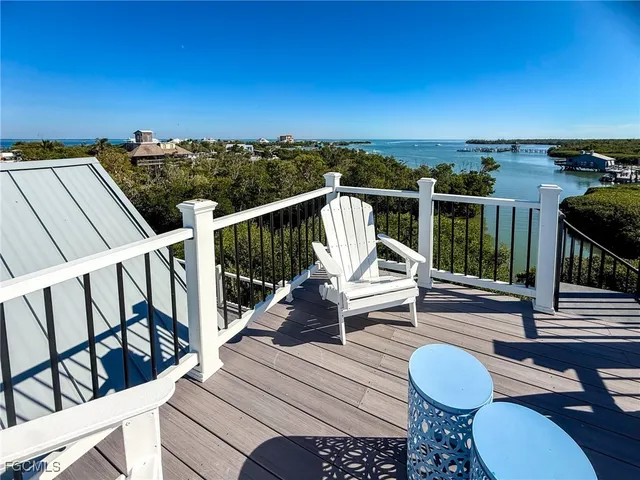 a view of a patio with table and chairs with wooden fence and plants
