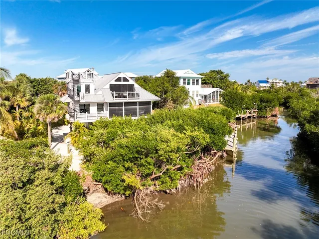 an aerial view of a house with a yard and lake view