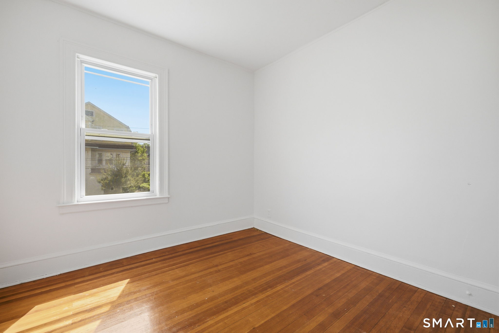 115 Baltimore Street, Unit 2 Hartford, CT 06112 - Photo 12 of 14 a view of an empty room with wooden floor and a window