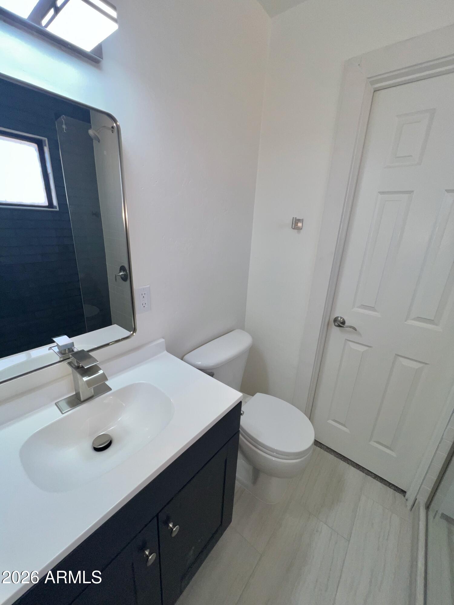 3818 West Ruth Avenue Phoenix, AZ 85051 - Photo 17 of 20 a bathroom with a sink toilet and mirror