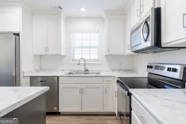 a kitchen with a sink stove and cabinets
