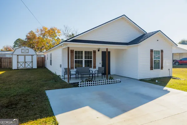 a front view of a house with a garden and yard