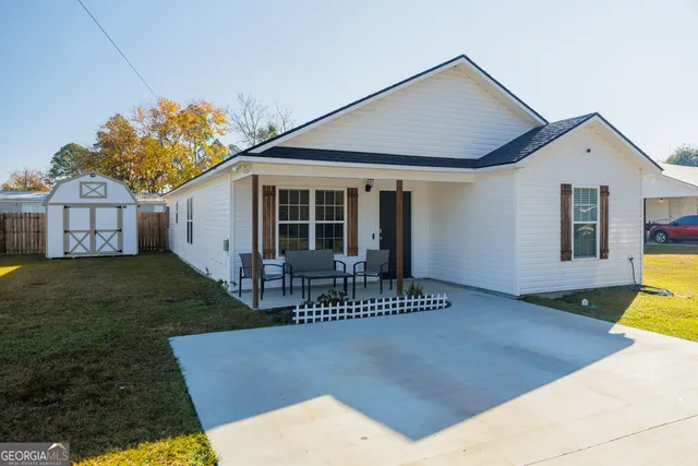 a front view of a house with a garden and yard