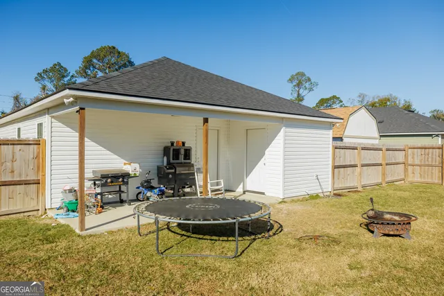 a view of a swimming pool with a bench and trees in the background