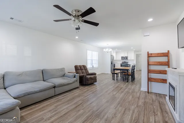 a living room with furniture and a wooden floor