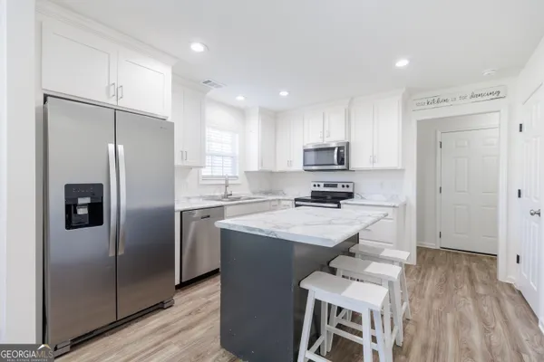 a kitchen with a refrigerator a sink and cabinets