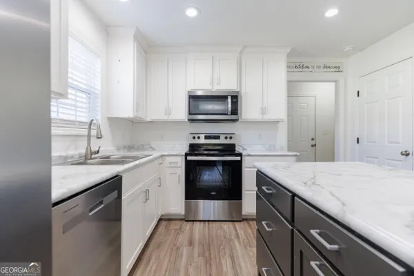 a kitchen with a sink stove and microwave