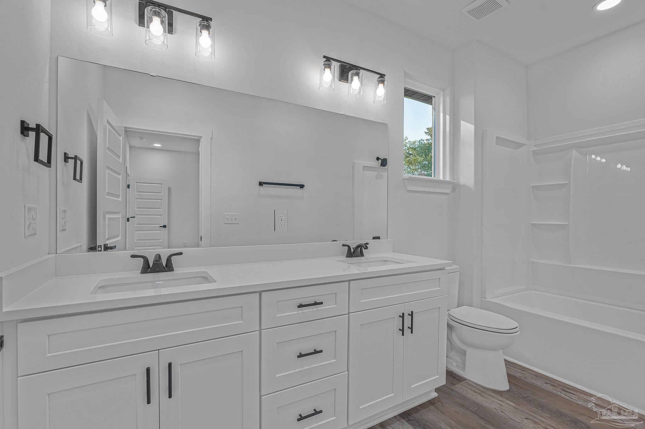 5005 Saufley Field Road Pensacola, FL 32526 - Photo 13 of 27 a bathroom with a toilet a sink a mirror a bathtub and vanity