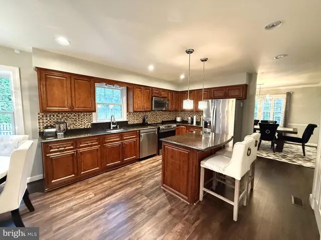 a kitchen with stainless steel appliances granite countertop a stove refrigerator and cabinets