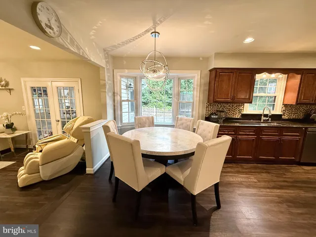 a kitchen with granite countertop a stove a sink a table and chairs