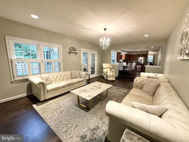 a living room with furniture kitchen and a wooden floor