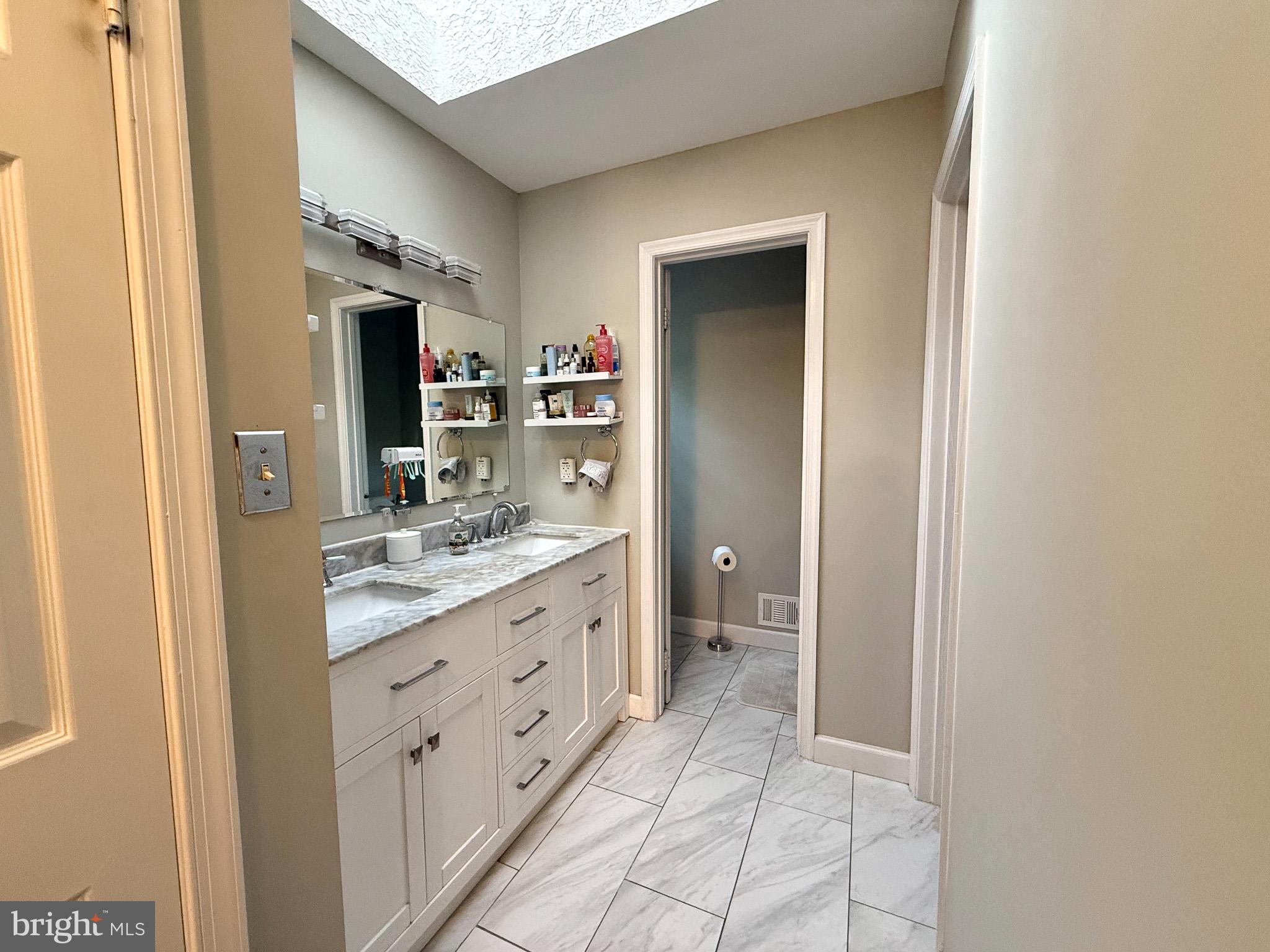6421 Spring Lake Drive Burke, VA 22015 - Photo 50 of 65 a bathroom with a double vanity sink and a mirror