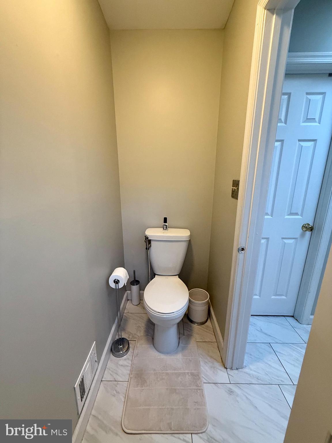 6421 Spring Lake Drive Burke, VA 22015 - Photo 51 of 65 a white toilet sitting next to a wooden cabinet