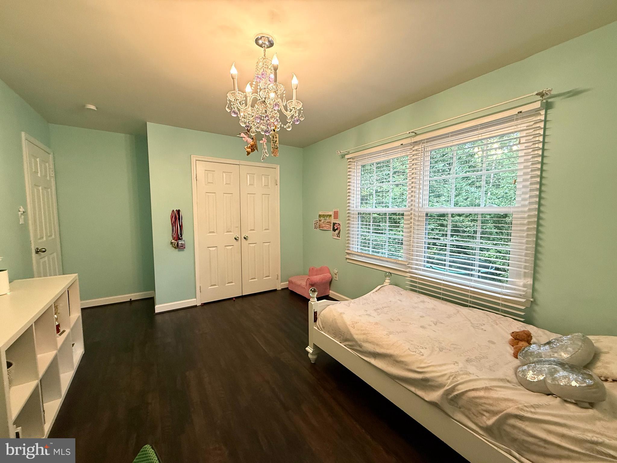 6421 Spring Lake Drive Burke, VA 22015 - Photo 57 of 65 a bedroom with a large bed and a chandelier next to a window