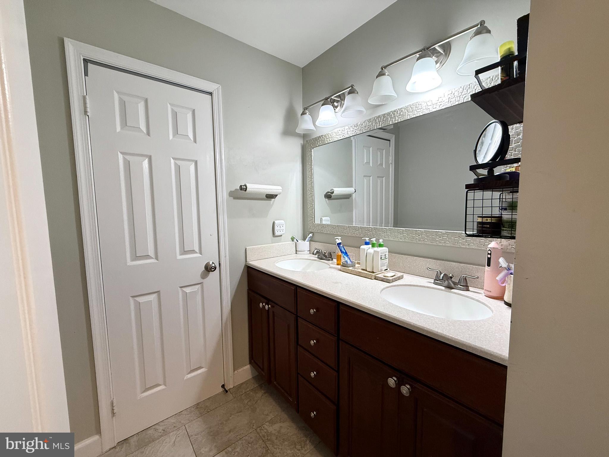 6421 Spring Lake Drive Burke, VA 22015 - Photo 58 of 65 a bathroom with a double vanity sink and mirror