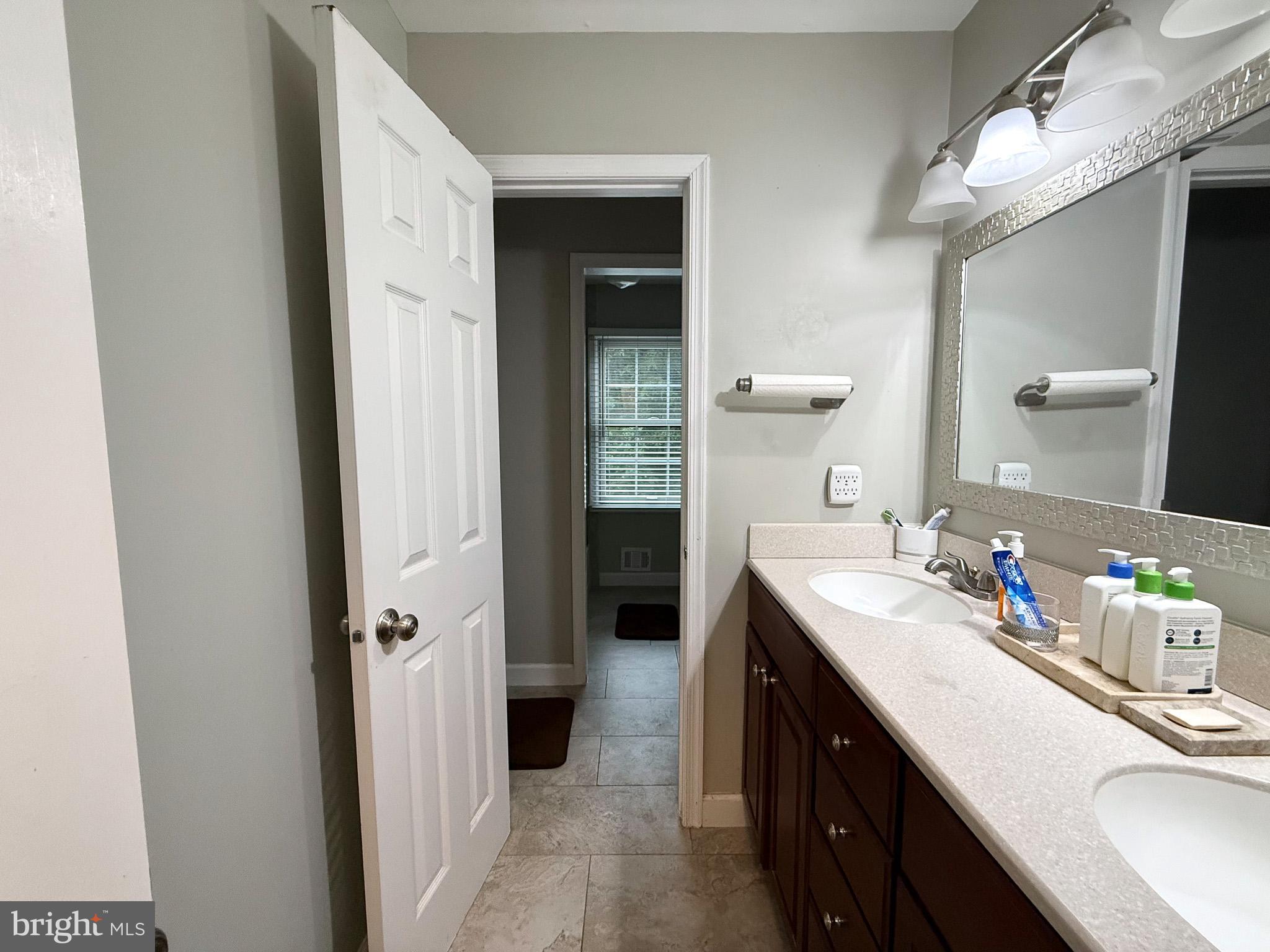 6421 Spring Lake Drive Burke, VA 22015 - Photo 59 of 65 a en suite bathroom with a double vanity sink a mirror and a shower
