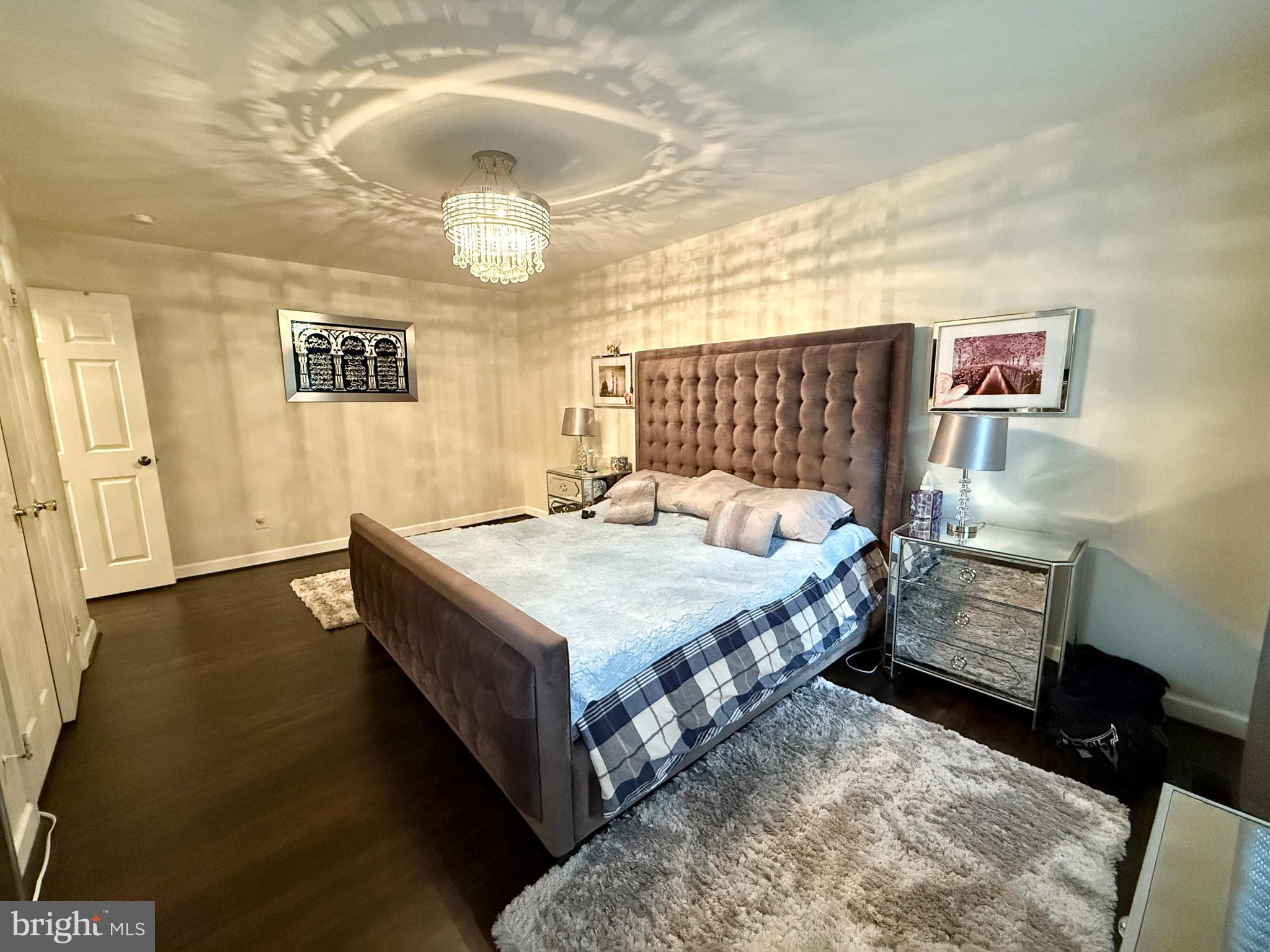 6421 Spring Lake Drive Burke, VA 22015 - Photo 65 of 65 a spacious bedroom with a bed and a chandelier