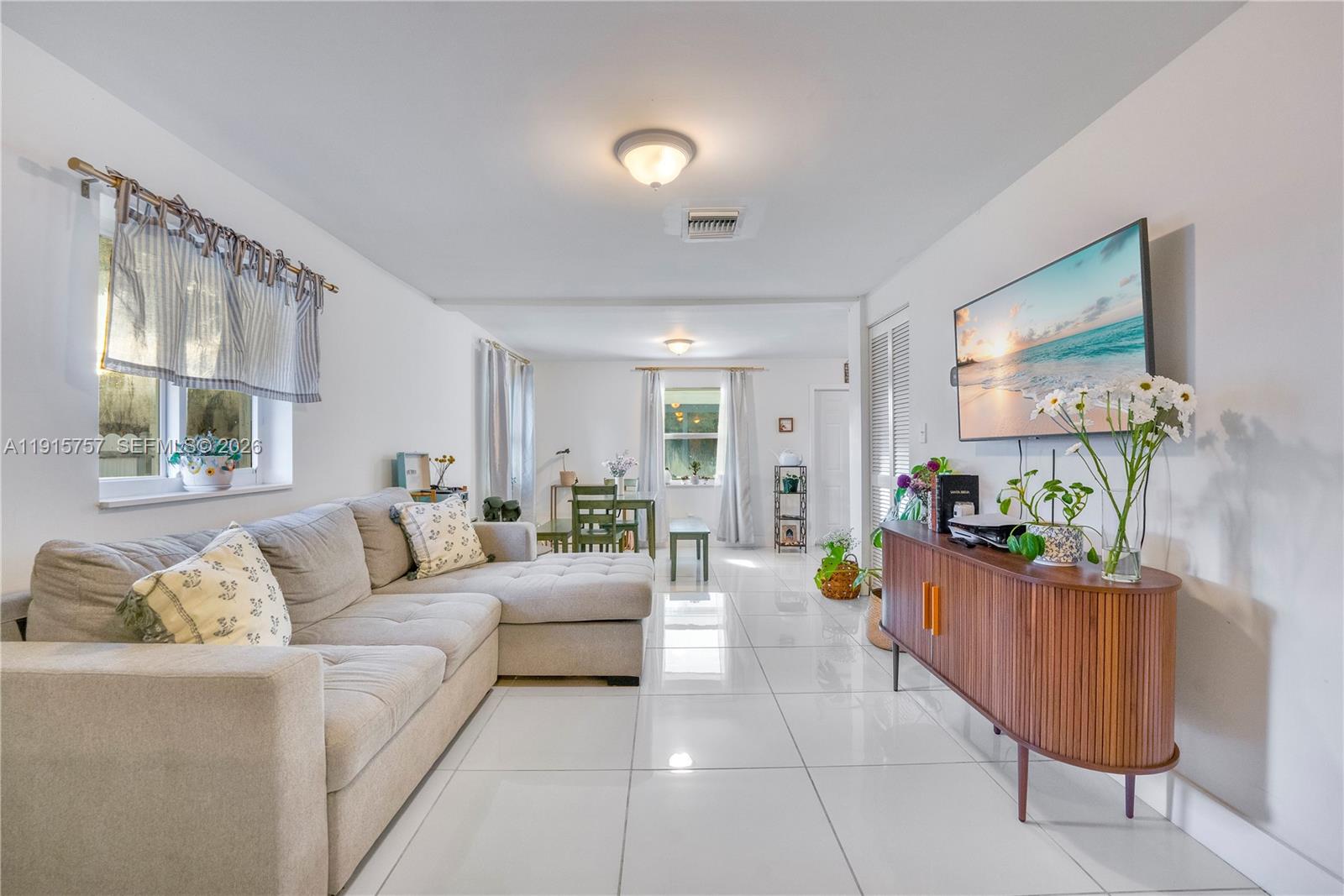 827 Northwest 114th Street Miami, FL 33168 - Photo 5 of 23 a living room with furniture and a flat screen tv