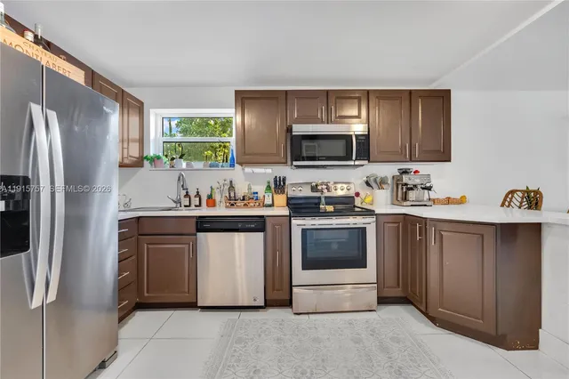 a kitchen with stainless steel appliances a stove microwave and refrigerator
