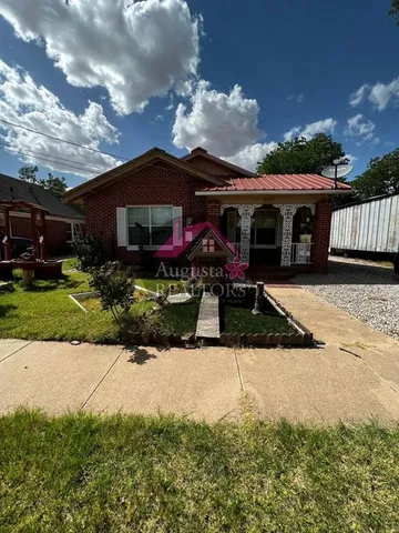 a view of a house with yard and sitting area