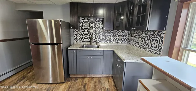 a kitchen with stainless steel appliances granite countertop a refrigerator and a sink