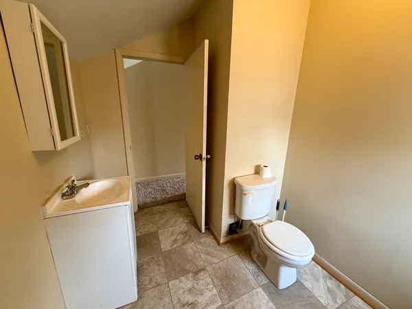 a bathroom with a sink a toilet and a mirror