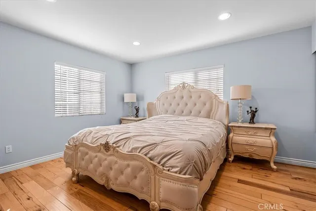 a large kitchen with stainless steel appliances granite countertop a large stove a refrigerator a sink and white cabinets with wooden floor