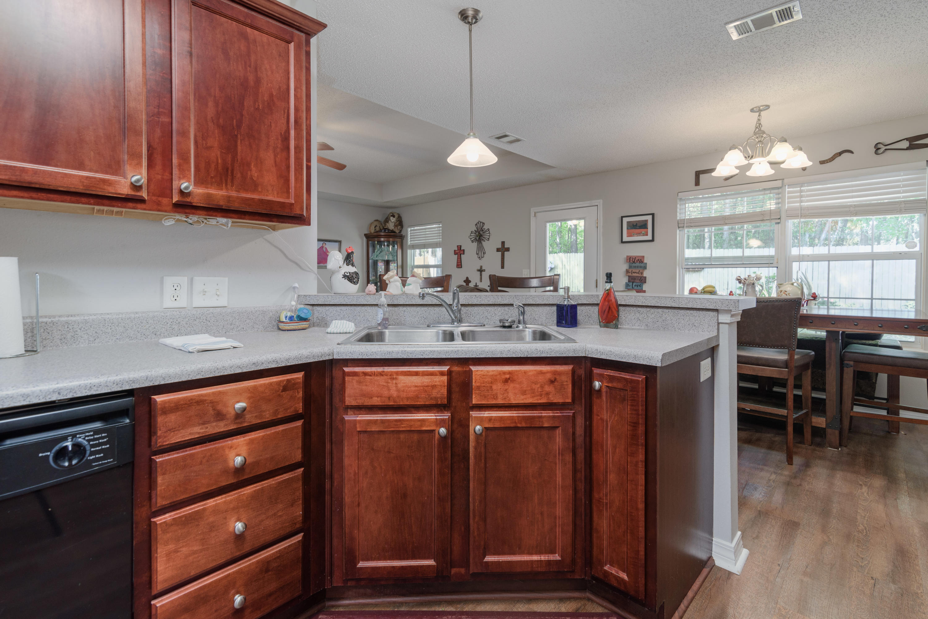 205 Tiffot Court Crestview, FL 32539 - Photo 12 of 32 a kitchen with stainless steel appliances granite countertop wooden cabinets a sink a stove a dining table and chairs