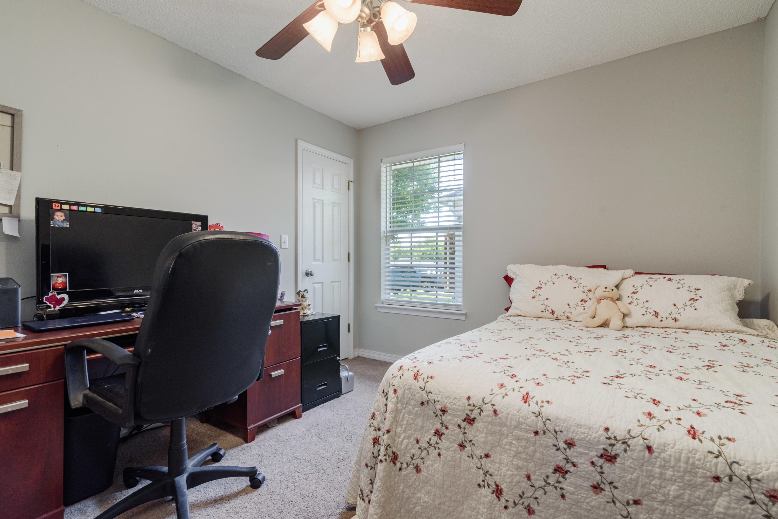 205 Tiffot Court Crestview, FL 32539 - Photo 22 of 32 a bedroom with a large bed and a chandelier