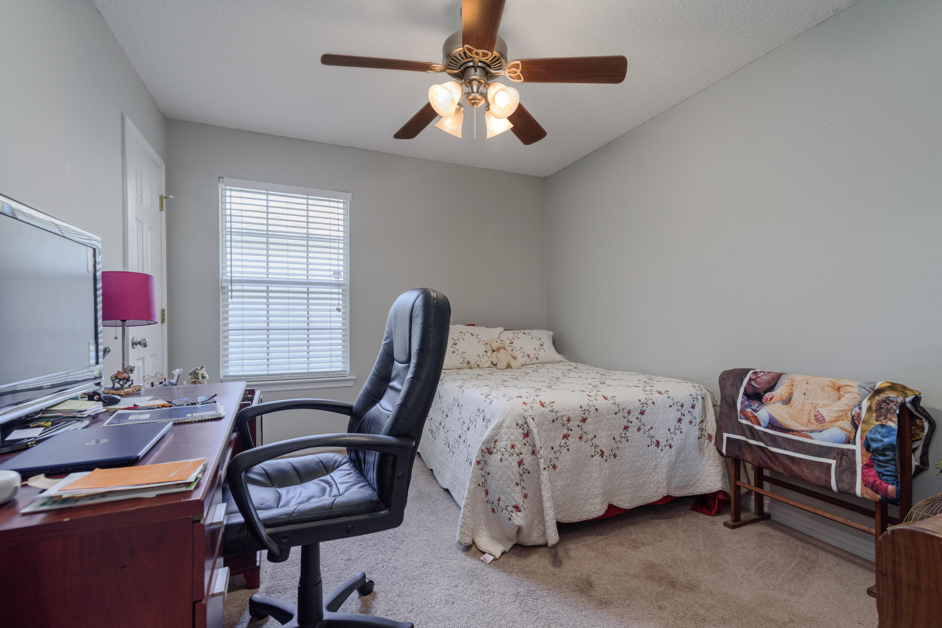 205 Tiffot Court Crestview, FL 32539 - Photo 27 of 32 a bedroom with a bed and a chandelier