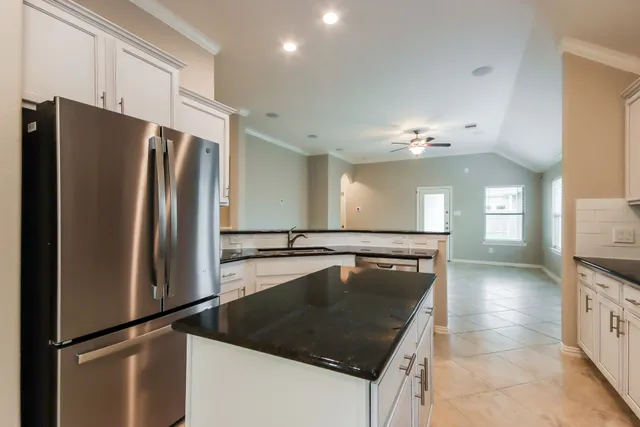 a kitchen with stainless steel appliances granite countertop a refrigerator a sink a stove and island
