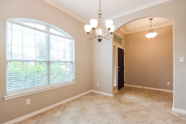 a view of a livingroom with a chandelier fan and windows