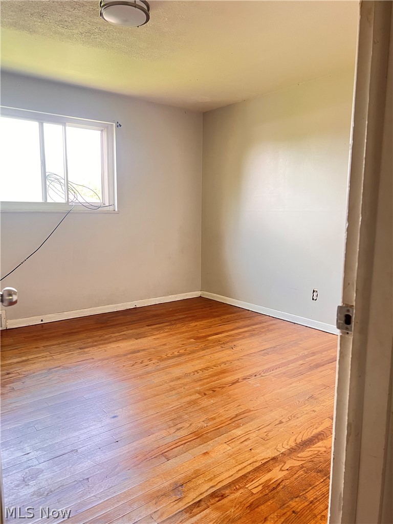 16350 Rockside Road Maple Heights, OH 44137 - Photo 25 of 34 Room featuring wood-finish flooring, a double window, and neutral wall tones