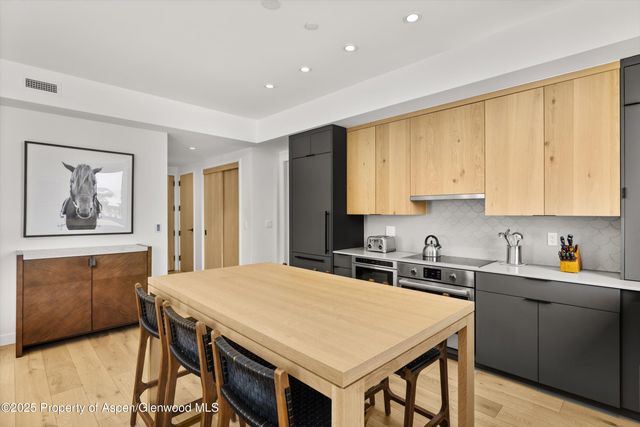 a kitchen with a table chairs sink and cabinets