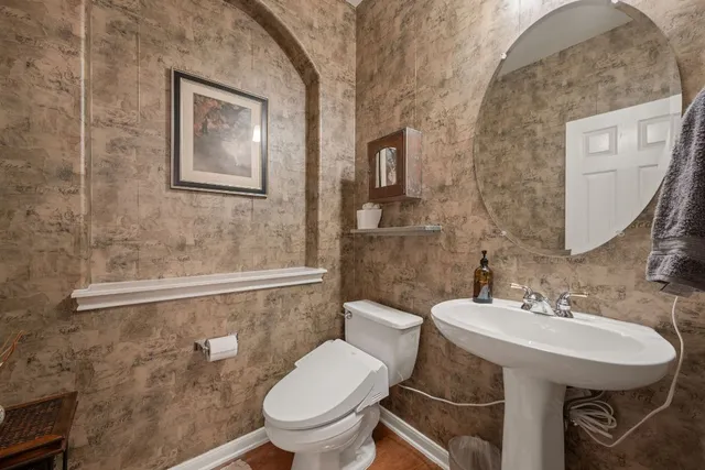 a bathroom with a toilet sink and mirror