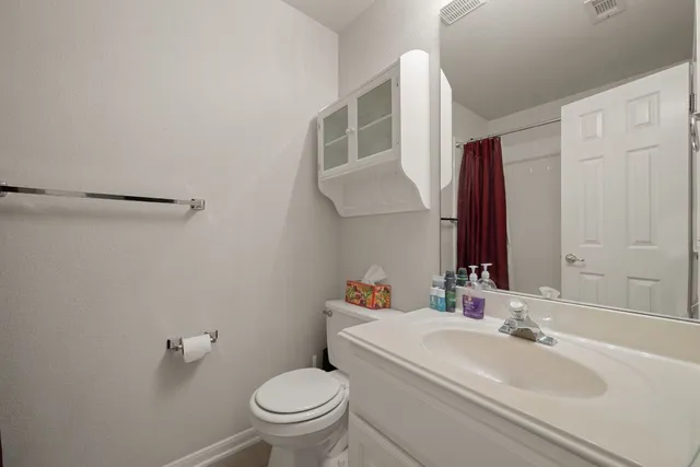 a bathroom with a sink a toilet and a mirror